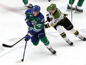 Dominic Jendijk, vlevo, ze Sudbury Wolves, a Michael Podoloch, z North Bay Battalion, závodí s pukem během hnutí OHL v Sudbury Community Arena v Sudbury, Ontario.  v pátek 11. března 2022. John Lappa / Sudbury Star / Postmedia Network