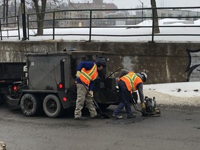 Greater Sudbury employees patch potholes on College Street near the underpass Wednesday morning. Harold Carmichael/Sudbury Star/Postmedia Network