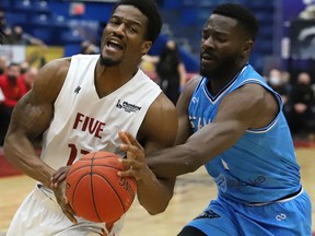 Marcel White, left, of the Sudbury Five, is fouled by Kobi Nwandu, of the Syracuse Stallions, during basketball action at the Sudbury Community Arena in Sudbury, Ont. on Friday March 18, 2022. The Five lost 117-104. read Ben Leeson's game story at thesudburystar.com. John Lappa/Sudbury Star/Postmedia Network