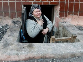 In the besieged port city of Mariupol, a local resident seeks refuge in the basement of a building on March 18. Attacks on Ukraine have been constant since Russia invaded the country on Feb. 24.