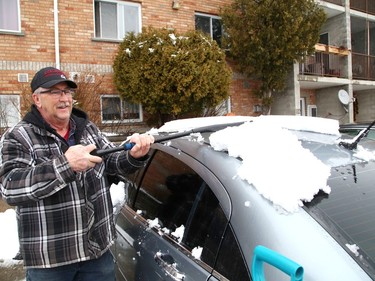 Steven Miller clears snow off his mother's car in Sudbury, Ont. on Thursday March 24, 2022. Environment Canada said Greater Sudbury can expect periods of snow changing to periods of rain or snow near noon on Friday. Temperature will reach 3 C. John Lappa/Sudbury Star/Postmedia Network