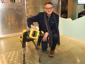 Greg Rickford, Minister of Northern Development, Mines, Natural Resources and Forestry, interacts with Spot the robotic dog, at a funding announcement at Dynamic Earth in Sudbury, Ont. on Friday March 25, 2022. John Lappa/Sudbury Star/Postmedia Network