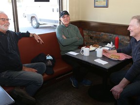 Ed Gorc, left, of Eddie's Sports Bar and Restaurant on Regent Street in Sudbury, Ont., chats with patrons Billy Shkrabek, middle, and Doug Pero on Monday March 28, 2022. The restaurant reopened after having to close because of a fire at The Barber Shop located at the same strip mall on March 16, 2022. John Lappa/Sudbury Star/Postmedia Network