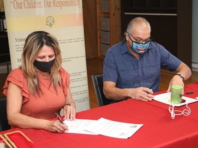 Sandra Martin, board president of N'Swakamok Native Friendship Centre, and Kevin Mossip, board chair of Kina Gbezhgomi Child and Family Services, sign a protocol agreement at the friendship centre in Sudbury, Ont. on Tuesday March 29, 2022. John Lappa/Sudbury Star/Postmedia Network