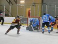 Crunch goalie Michael Nickolau fends off an attempt by the Timmins Rocks in a rare mid-week afternoon game on St. Patrick's Day. NOJHL photo