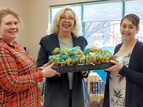 Leanna Wlad-Neale from Metis Nation of Ontario  and Catherine Colton of Ininew Friendship Centre present Christina Blazecka, CEO of the Cochrane Public Library with the kits.