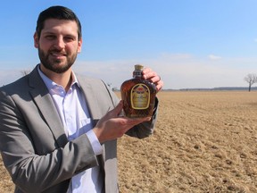 Matthew Slotwinski, with the Sarnia-Lambton Economic Partnership, holds a bottle of Crown Royal whisky at the site of a new distillery to be built on Moore Line in St. Clair Township. Paul Morden