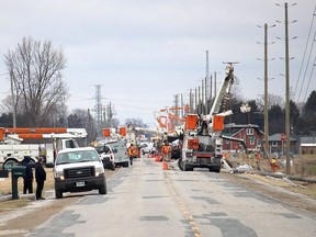 Hydro One crews were kept busy March 24 replacing hydro poles on Base Line Road, just outside of Wallaceburg, that were toppled by high winds the night before. Ellwood Shreve/Postmedia