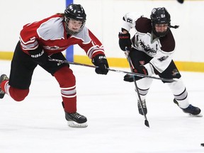 Lambton Central Lancers' Teagan Cox (left) and Wallaceburg Tartans' Taryn Jacobs chase the puck during the LKSSAA 'A/AA' girls' hockey final at Wallaceburg Memorial Arena on March 24. Mark Malone/ Postmedia Network