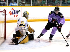 Cedrick Guindon intenta arrastrar el disco alrededor del portero Anson Thornton mientras Alexis Daviault sigue la jugada en el primer tiempo mientras el Owen Sound Attack presenta el Sarnia Sting para Hockey Fights Cancer Night en apoyo de la Canadian Cancer Society el sábado 26 de marzo de 2022 en la costa de la bahía en Owen Sound. Greg Cowan/The Sun Times