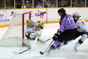 Anson Thornton aleja el disco de Lorenzo Bonaiuto en el primer tiempo mientras el Owen Sound Attack organiza el Sarnia Sting para Hockey Fights Cancer Night en apoyo de la Canadian Cancer Society el sábado 26 de marzo de 2022 en Bayshore en Owen Sound. Greg Cowan/The Sun Times