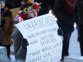 Olga Safroshkina holds a sign during the Stand With Ukraine rally at the Manitoba Legislative Building in Winnipeg on Sunday, March 6, 2022.