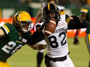 Edmonton Elks’ Jordan Hoover (28) tackles Hamilton Tiger-Cats’ Steven Dunbar Jr. (82) during first half CFL action at Commonwealth Stadium in Edmonton, on Friday, Oct. 29, 2021. Hoover and the club came to an agreement on a one-year contract for next season.