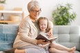 Grandmother reading a book to granddaughter.