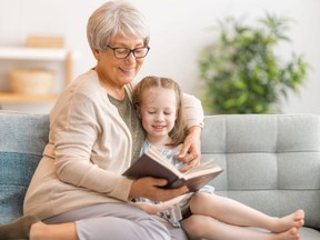 Grandmother reading a book to granddaughter.