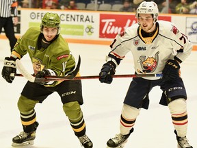 Owen Van Steensel of the North Bay Battalion and the visiting Barrie Colts' Tyson Foerster prepare for a puck battle in an Ontario Hockey League game Sunday. The Troops, who won 6-3, can capture the Central Division title Thursday night against the Mississauga Steelheads.
Sean Ryan Photo