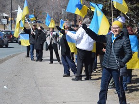 Members of the local Ukrainian community, along with supporters, take part in a rally on Sunday afternoon near Hnatyshyn Park.