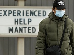 A pedestrian makes their way past a help wanted sign at a Jiffy Lube location, 9927 82 Ave. in Edmonton on March 15, 2022. PHOTO BY DAVID BLOOM / Postmedia, file.