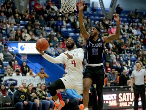 Dexter Willams Jr. (4) of the Sudbury Five goes up for a layup against Joel Kindred (12) KW Titans during NBLC action at Sudbury Community Arena in Sudbury, Ontario on Saturday, March 26, 2022.