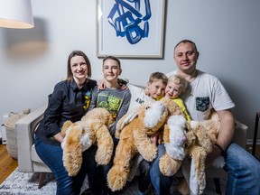 From left, Tetiana Kyryliuk, 10-year-old Dimitri Bulyshev, seven-year-old Alex Bulyshev, two-year-old Nastya Bulysheva and Denys Bulyshev sit in the living room of their new home in Belleville after escaping the ongoing war in Ukraine, Thursday in Belleville, Ontario. ALEX FILIPE