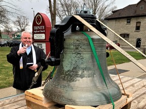 Rev. Paul Sherwood blesses the 129-year-old bronze bell at Trinity Anglican Church in Simcoe Thursday before the 800-pound dinger was returned to its belfry. – Monte Sonnenberg