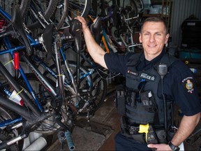 const.  Darren Fischer, the Stratford Police Services' community resource and media relations officer, stands next to dozens of stolen and abandoned bikes officers have been trying to return to their original owners.  To try and improve the process, Stratford Police is joining a North American bicycle registry and launching a campaign asking area cyclists to participate.  (Chris Montanini/Stratford Beacon Herald)