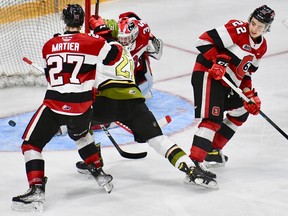Brandon Coe of the visiting North Bay Battalion scores in overtime Monday night despite the attention of Jack Matier and efforts of goaltender Max Donoso of the Ottawa 67's behind defender Matthew Mayich. The Troops can wrap up their Ontario Hockey League first-round playoff series Wednesday night.
Matt Ryan Photo