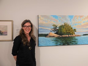 Melissa Jean with "Power of Place," one of 12 of her paintings currently on display at The Muse. Photo by Bronson Carver
