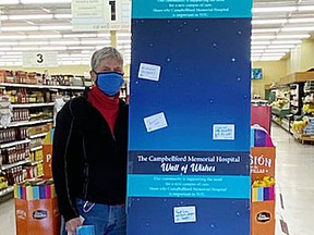 Campbellford Memorial Hospital volunteer Rachel Corbett stands next to the Wall of Wishes at Marmora's Valu-Mart store.
