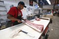 Hashit Haneem, a butcher at SK Quality Meats, cuts up porkloin and loads in into the display case at St. Lawrence Market on Wednesday, April 20, 2022.