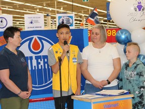 Elijah speaks at last week’s ceremony at Walmart while flanked by moms Sue and Tracie and brother Nate. (Sheena Riener, Stollery Children's Hospital Foundation)