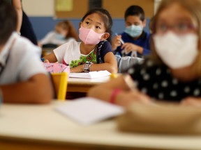 Schoolchildren are shown wearing masks in class in this 2020 file photo. Reuters