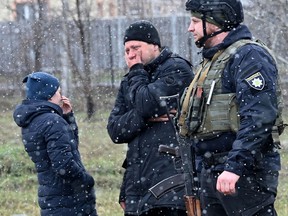 People react as they gather close to a mass grave in the town of Bucha, just northwest of the Ukrainian capital Kyiv on April 3, 2022. (SERGEI SUPINSKY/AFP via Getty Images)