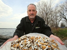 Belleville's John Lowry opens a bag containing more than 25,000 cigarette butts he has gathered this month. The volunteer pickup is part of a national campaign to collect and recycle them. Lowry started the week as the third-ranked collector nationally.
