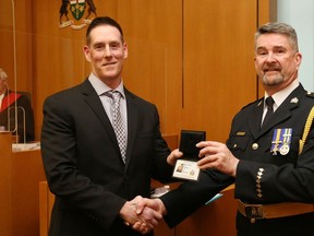 New Belleville Police Const. Khoby Langdon receives his badge from Chief Mike Callaghan during a Monday-afternoon ceremony in Belleville's Quinte courthouse.