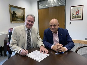 Brantford Mayor Kevin Davis on Friday signs an agreement to officially twin the city with Kamianets-Podilskyi in southwest Ukraine. With him is Brantford-Brant MP Larry Brock. Submitted