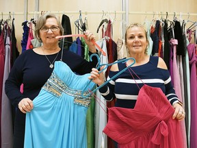 Debbie Franklin and Geri Hughson of FreeHelpCK hold up some of the prom dresses available at their location in the Downtown Chatham Centre.  The dresses are available to graduating high school students for free.