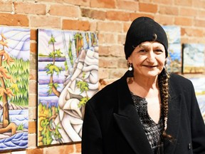 Chatham artist Tracy Root is shown next to paintings from Prism of Perception, her exhibition at ARTspace in downtown Chatham. Tom Morrison/Chatham This Week