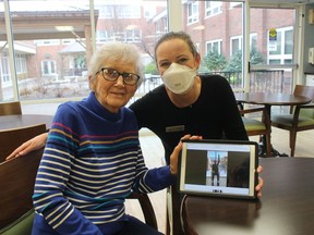 Betty Jenner, 93, a resident of St. Andrew's Residence in Chatham and Mindy Jenner, resident and client relations manager, display one of virtual exercise classes residents have been able to enjoy on new iPads, which were among the items purchased with a $137,700 Ontario Trillium Foundation grant. Ellwood Shreve/Postmedia