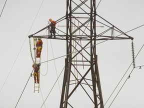 Workers from Hydro One work on a transmission tower in this file photograph from 2017.