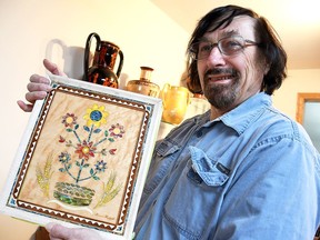 Chatham artist Bernie Hrytzak holds up a book cover he designed for a Ukrainian cultural museum in Saskatoon inside his home on Thursday. He will present it at ARTspace in Chatham on April 7 before he delivers it to the museum. PHOTO Tom Morrison/Postmedia