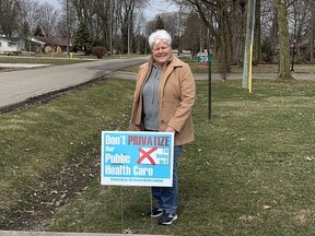 Heather Kavanagh, of Chatham, is shown with a lawn sign from the Ontario Health Coalition with a message against health care privatization. Area health coalitions are holding a virtual event on the issue on April 7.