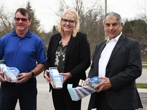 Rotary Club of Chatham Sunrise members Roger McRae, left, Leigh-Anne Perrin and Paul Roy hold boxes of sunflower seeds, which will be distributed in the community as part of a fundraiser to support humanitarian efforts in Ukraine. PHOTO Tom Morrison/Postmedia