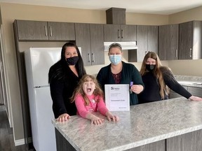 Anne Taylor, left, volunteer manager with Habitat for Humanity Chatham-Kent, is seen here with Mel Dramnitzke and her daughters, the day the received the keys to their new home in Wallaceburg. (Supplied photo)
