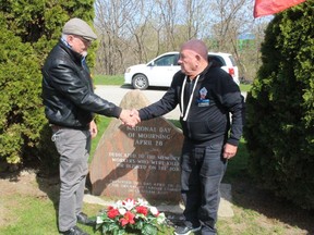 Long-time labour activists Derry McKeever, left, and Bill Zilio, shake hands after placing flowers at a monument to recognize fall workers on Thursday during an event organized by Unifor to mark the National Day of Mourning. PHOTO Ellwood Shreve/Chatham Daily News