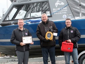 The Dave Mounsey Memorial Fund (DMMF) donated a defibrillator in Grand Bend April 27 which will be kept on a Blue Line Fishing Charters boat and can be used to respond to emergencies on the water or at the beach. Pictured from left are DMMF co-founder Patrick Armstrong, Fred Wondergem of Blue Line Fishing Charters and Lambton OPP (semi-retired) and DMMF co-founder Dave Matheson. Scott Nixon