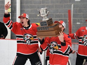 Sean Chisholm (15), Malcolm McLeod and Evan Dowd of the Mitchell Hawks rush the PJHL Pollock Division trophy to the rest of their teammates after their Game 7 victory in Hanover April 16. ANDY BADER/MITCHELL ADVOCATE