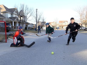 Alex Ladouceur is the goaltender as Rowan Lockwood and William Harris run for the ball during the Play Street closing of Cheryl Place in Kingston on Tuesday.