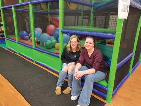 Photo by Jacqueline Rivet
Owner Ashley Moga (left) and employee Serena Golden sit inside a cubby hole beside the bouncy ball pit. Some of the activities at Moga Mania include slides, climbing and bouncing features. All are designed to encourage children to have fun while becoming physically active.