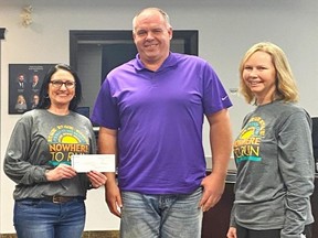 Calmar Mayor Sean Carnahan was pleased to receive a $1,300 donation earmarked for trail development from Monique Arksey and Jaclyn Evaschyshyn of Nowhere to Run. (Nowhere to Run)